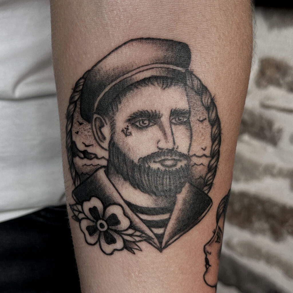 Tatouage style traditionnel en noir et gris d'un portrait de marin