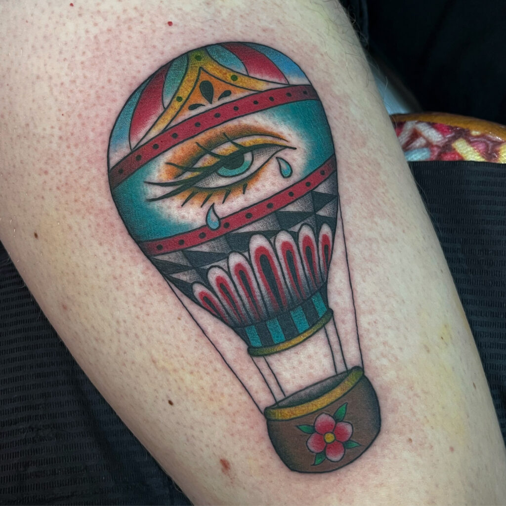 Tatouage style traditionnel en couleur d'une montgolfière avec un oeil